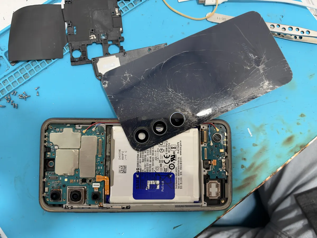 The Galaxy A35 opened on a blue repair mat, back glass removed